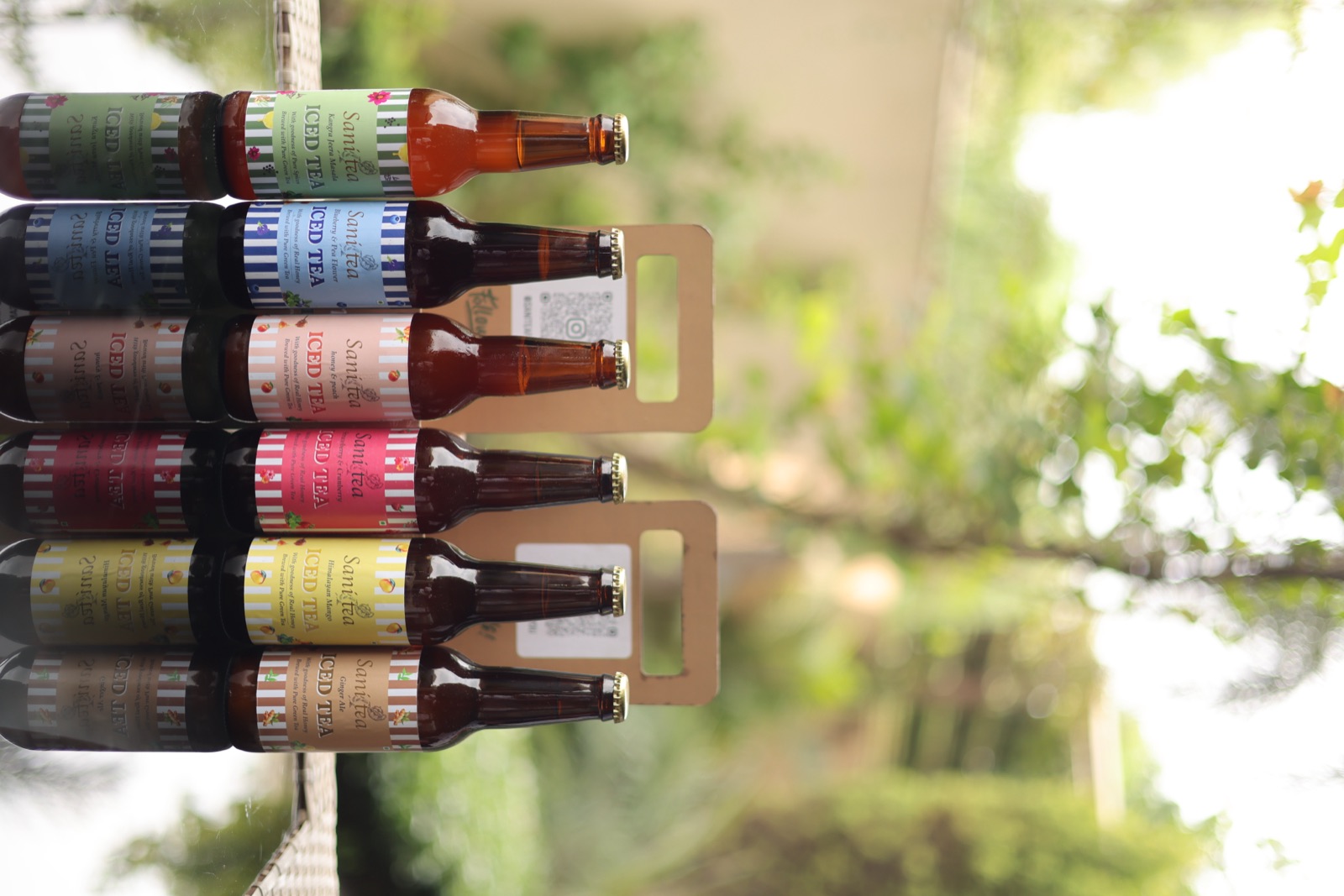 Six Sanitea iced tea flavours lined up in the garden